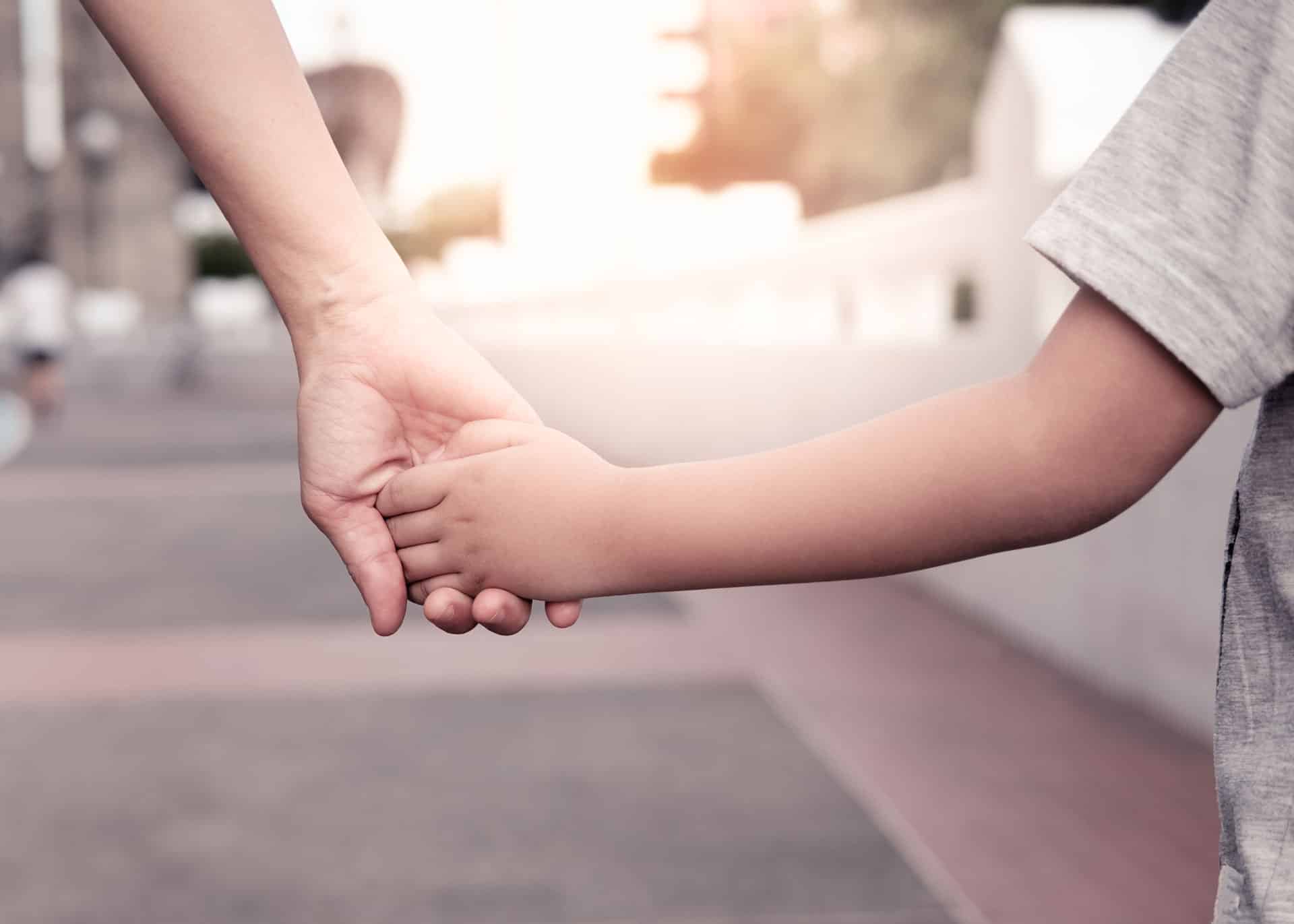 Parent Holding the Hand of A Small Boy | Child Support Colorado | Law Offices of Clifton Black